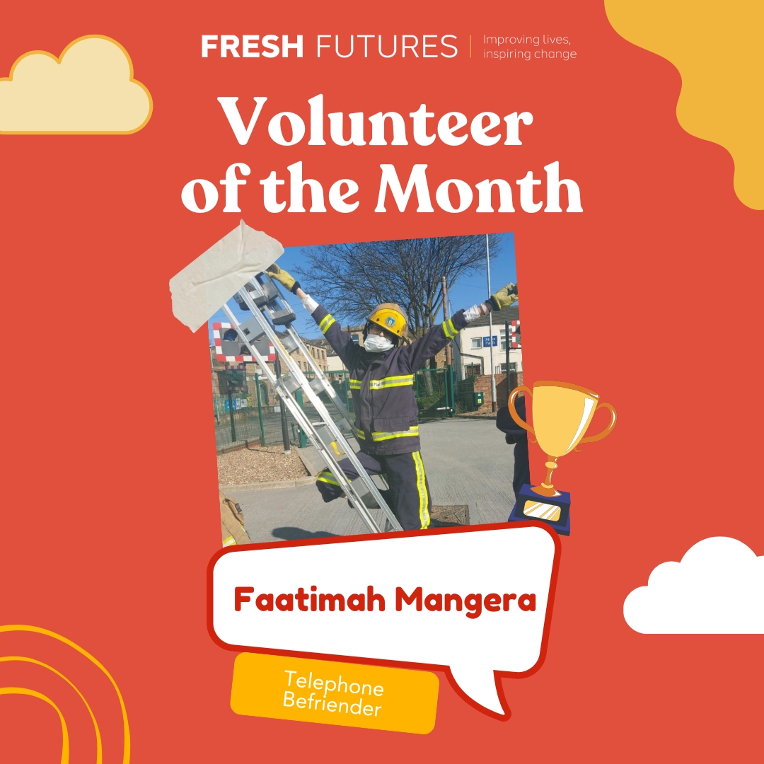 Bright, cheerful poster for ‘Fresh Futures’ announcing its ‘Volunteer of the Month.’ A central photo, tilted playfully, shows a volunteer dressed in full firefighter gear standing part-way up an outdoor ladder, arms raised triumphantly against a blue-sky backdrop. Around the photo are cartoon clouds, curved yellow shapes and a small gold-trophy icon. Large white headline text reads ‘Volunteer of the Month.’ Beneath the picture, a speech-bubble panel displays the volunteer’s name in bold red letters, and a yellow tag below notes their role as ‘Telephone Befriender.’