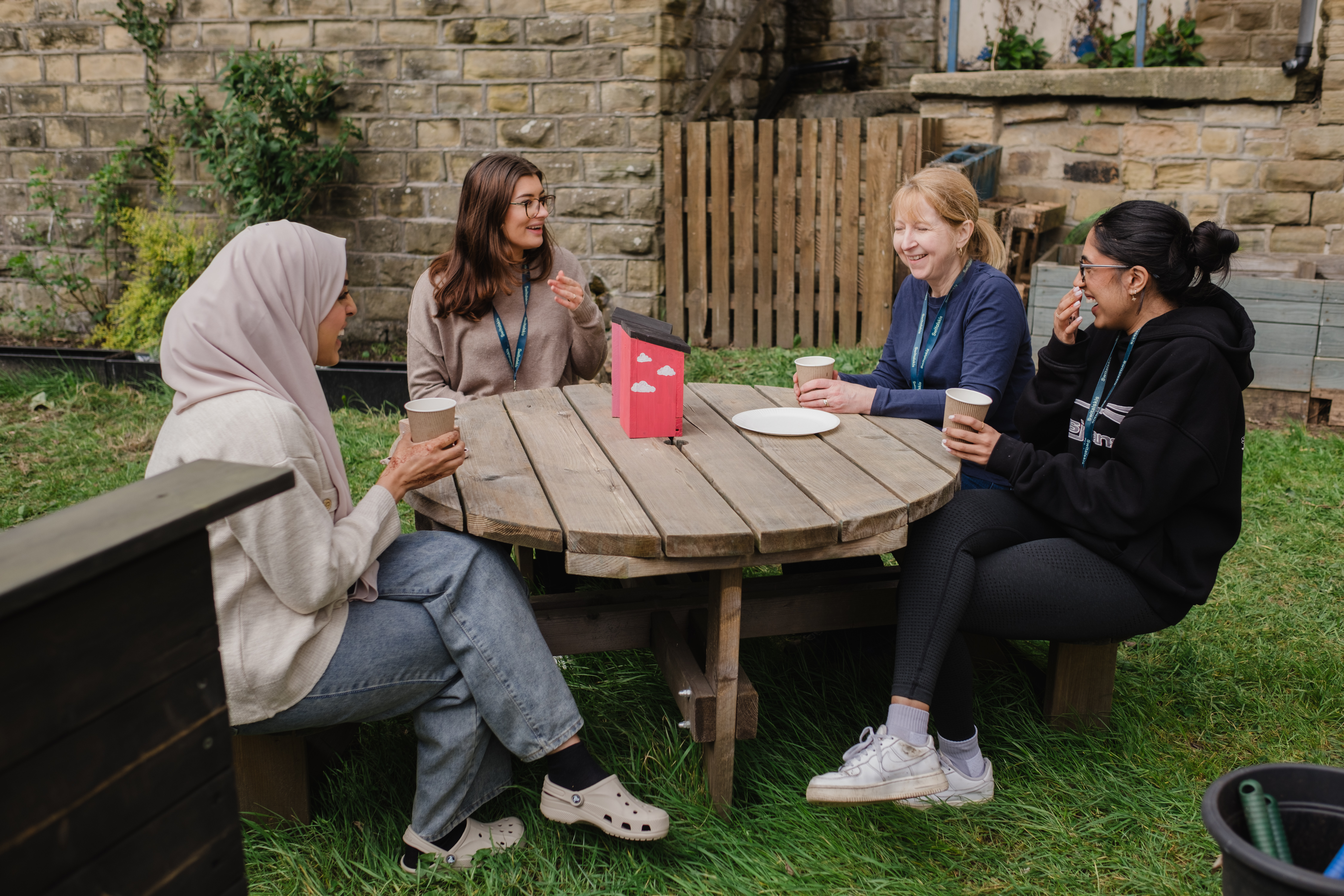 Fresh Futures volunteers and partners sat around the table in the garden