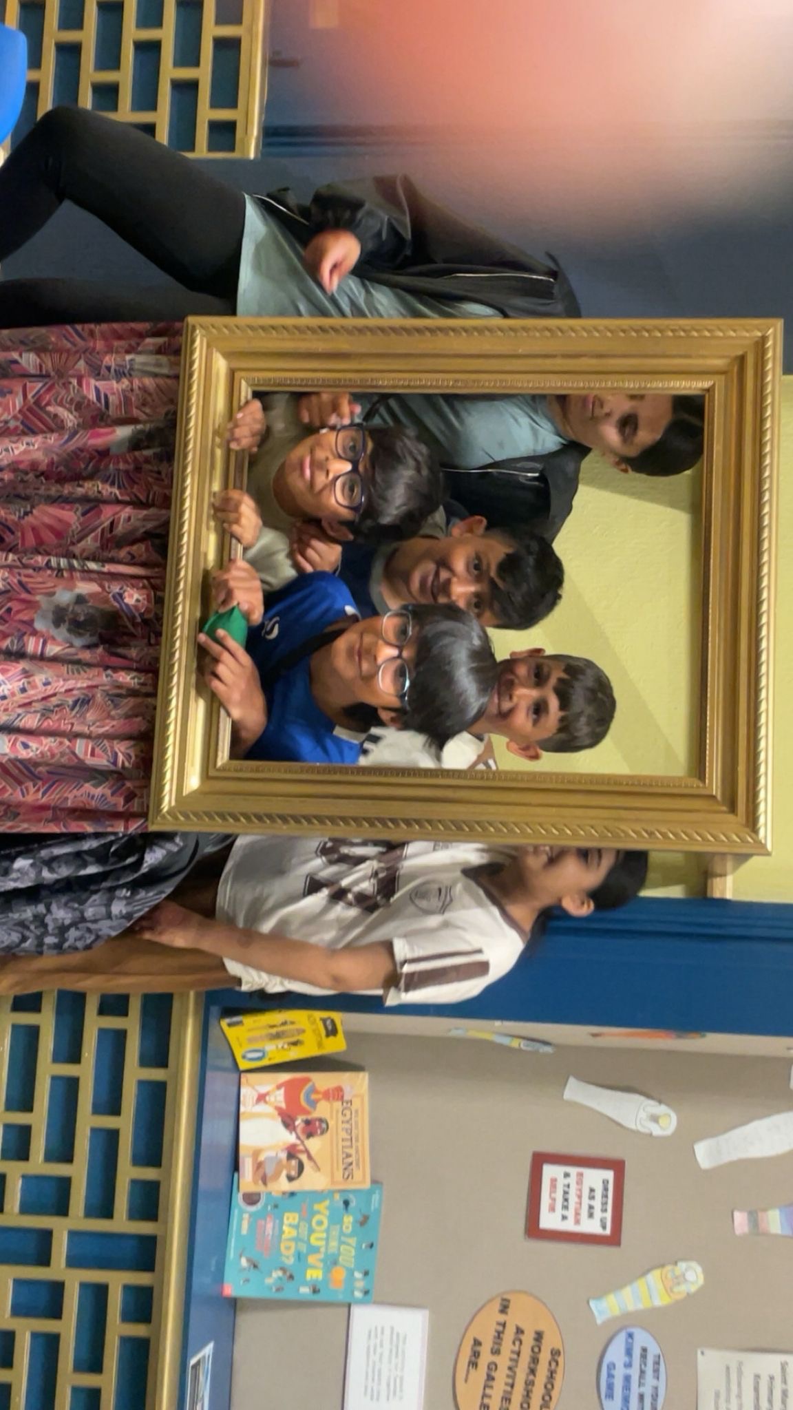 Haf children in a picture frame at a museum posing